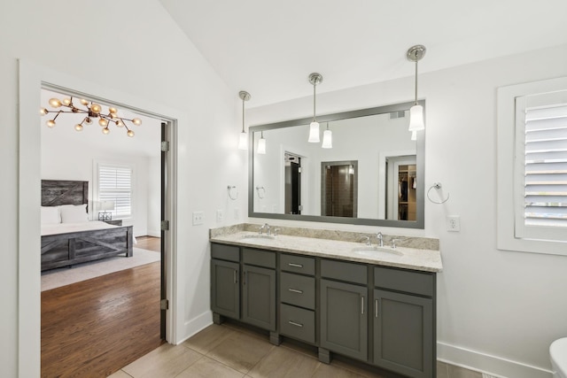 full bathroom with visible vents, lofted ceiling, double vanity, and a sink