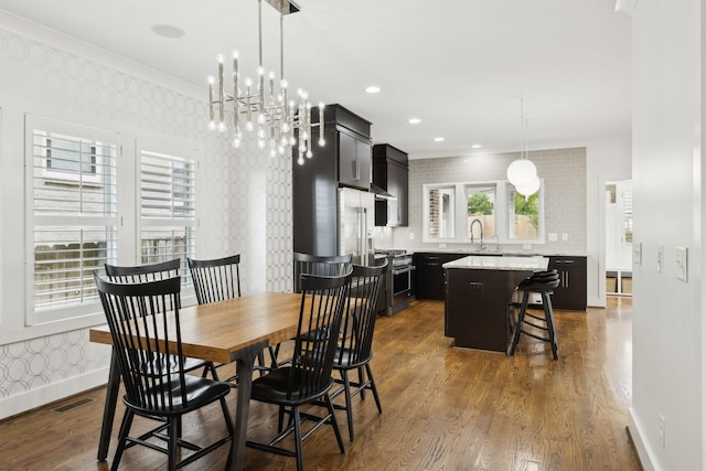 dining area featuring dark wood-type flooring, visible vents, crown molding, and baseboards
