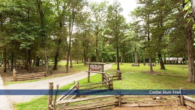 view of community featuring a yard and fence