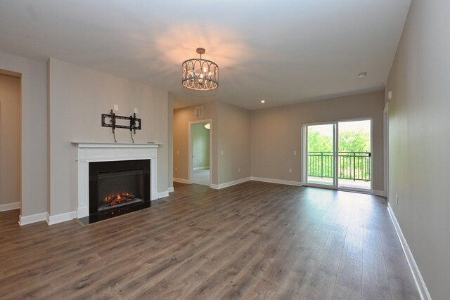 141 Saundersville Rd Unit 1305, Hendersonville, TN 37075 - unfurnished living room featuring baseboards, wood finished floors, an inviting chandelier, and a fireplace with flush hearth