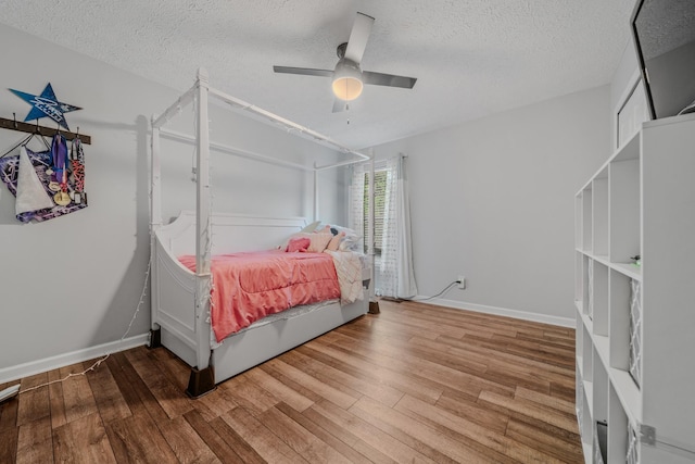 2011 Mccrory Pl, Spring Hill, TN 37174 - bedroom featuring a textured ceiling, ceiling fan, wood finished floors, and baseboards