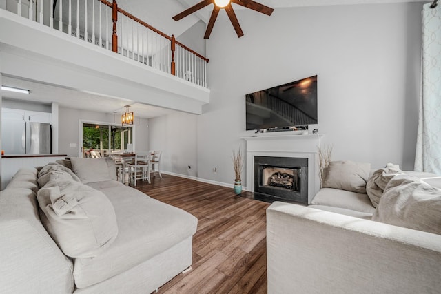 2011 Mccrory Pl, Spring Hill, TN 37174 - living area featuring wood finished floors, baseboards, high vaulted ceiling, a ceiling fan, and a fireplace with flush hearth
