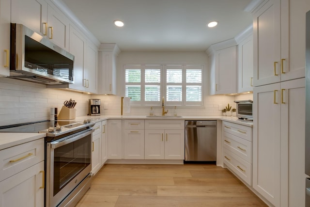 kitchen with white cabinetry, stainless steel appliances, recessed lighting, and a sink