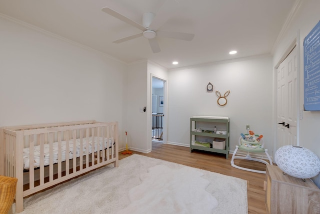 bedroom featuring baseboards, recessed lighting, wood finished floors, and crown molding