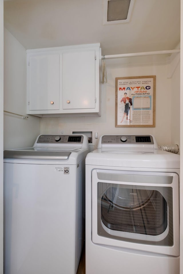 clothes washing area featuring cabinet space and independent washer and dryer