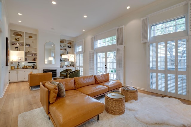 living area featuring ornamental molding, light wood finished floors, recessed lighting, and a fireplace