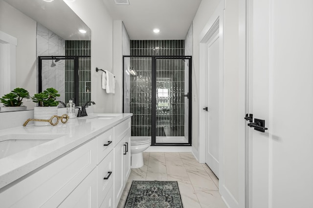 full bathroom with a shower stall, double vanity, marble finish floor, toilet, and a sink