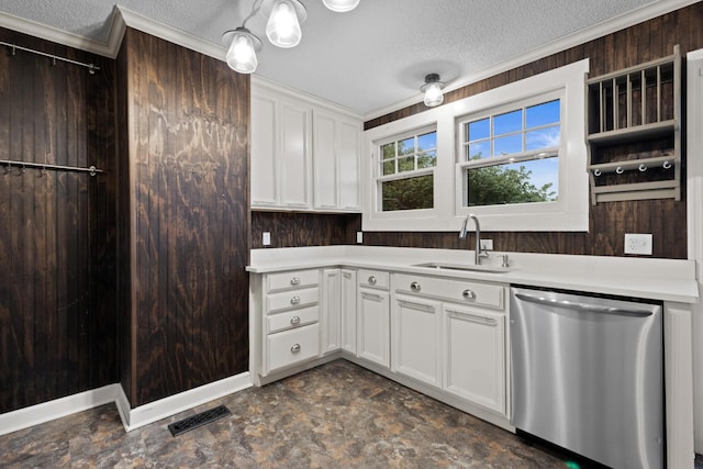 kitchen with a textured ceiling, light countertops, stainless steel dishwasher, and a sink