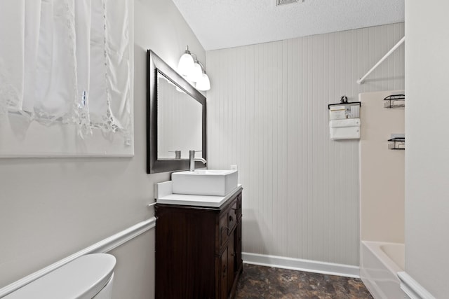 full bath featuring a textured ceiling, visible vents, baseboards, toilet, and vanity