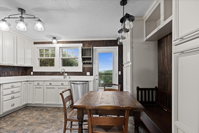 kitchen featuring a sink, white cabinetry, light countertops, a textured ceiling, and dishwasher