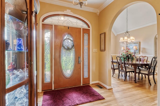 3668 Stonecreek Dr, Spring Hill, TN 37174 - foyer entrance with ornamental molding, baseboards, arched walkways, light wood-style flooring, and a notable chandelier