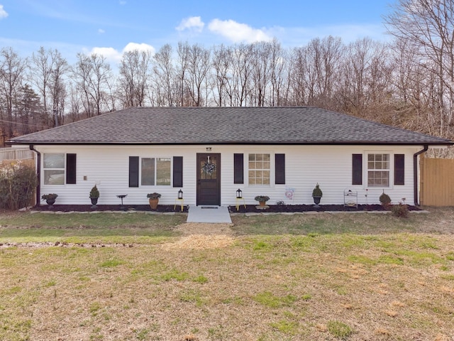 ranch-style home with fence, a shingled roof, and a front yard