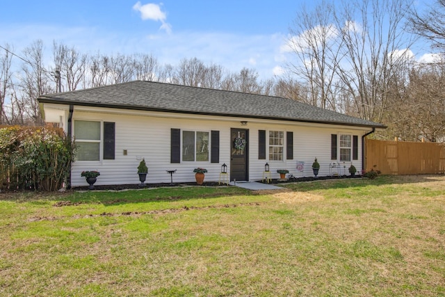 single story home with a front lawn, a shingled roof, and fence