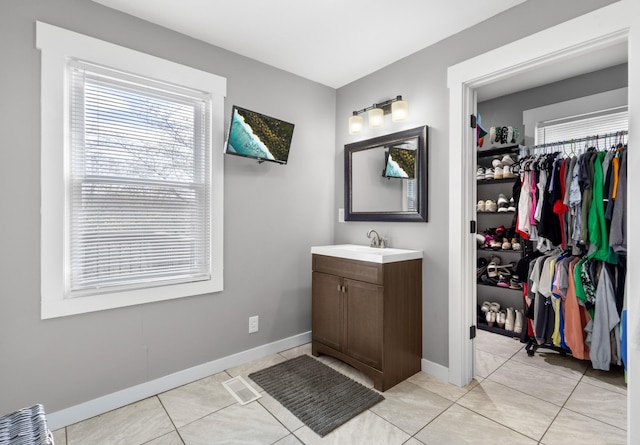 bathroom featuring baseboards, tile patterned flooring, and vanity