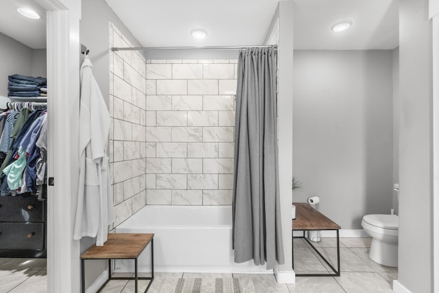full bath with baseboards, toilet, shower / bath combination with curtain, a spacious closet, and tile patterned flooring