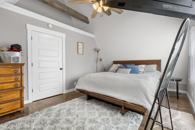bedroom with a ceiling fan, beam ceiling, wood finished floors, and baseboards