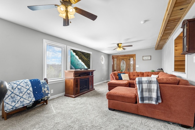 carpeted living area with a fireplace, ceiling fan, and baseboards