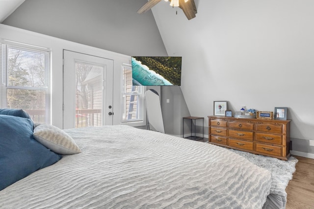 bedroom with access to exterior, baseboards, wood finished floors, a ceiling fan, and high vaulted ceiling