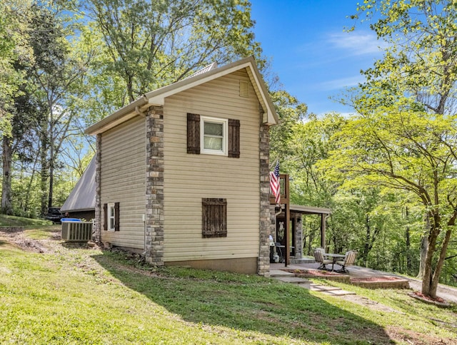 view of home's exterior with a lawn, cooling unit, and a patio