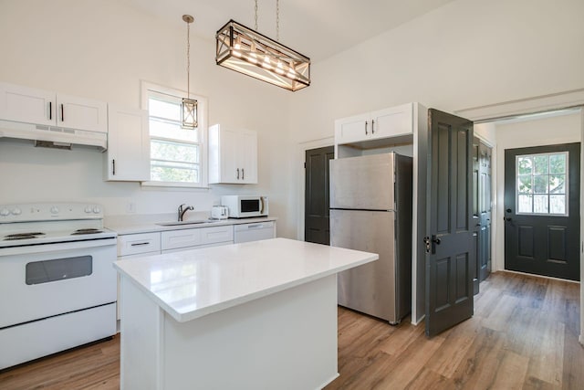 kitchen featuring a sink, under cabinet range hood, white appliances, white cabinetry, and light countertops