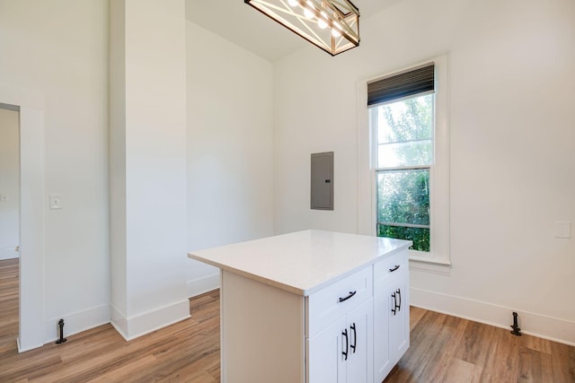 kitchen featuring baseboards, white cabinets, light countertops, and light wood-style flooring