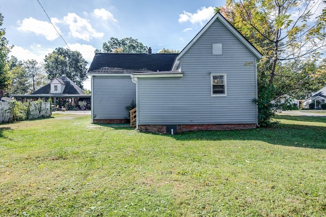 back of house with a lawn and a shingled roof