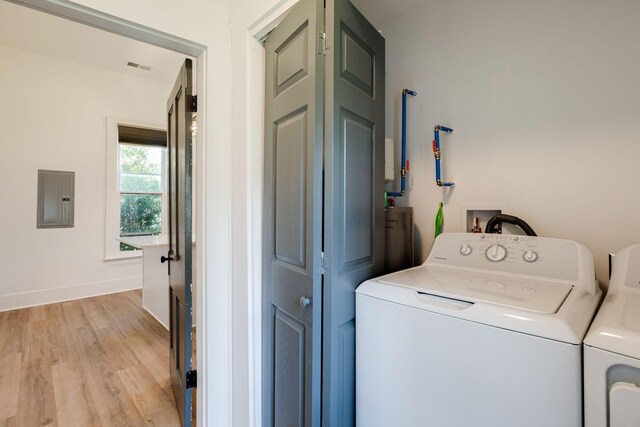 laundry room with laundry area, light wood-style floors, electric panel, washing machine and dryer, and baseboards