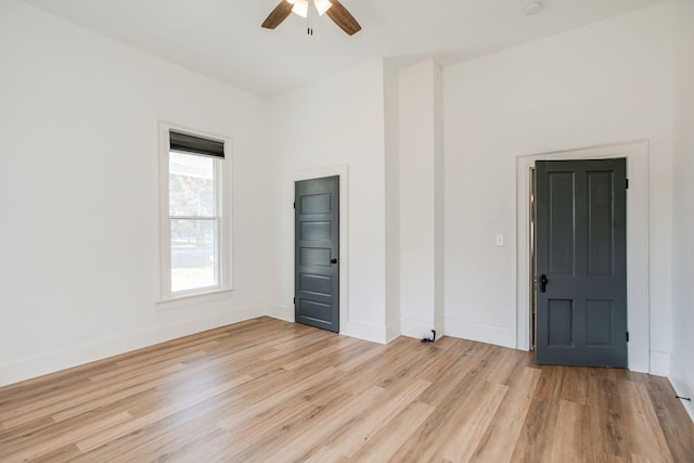 empty room with ceiling fan, baseboards, and light wood-style floors