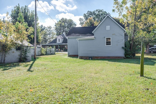back of house featuring a lawn and fence