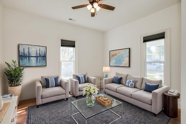 living room with wood finished floors, ceiling fan, and visible vents