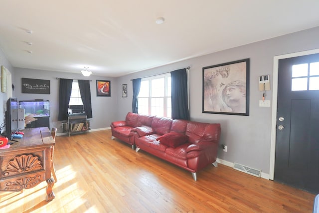 living room with visible vents, a wealth of natural light, and light wood-style flooring