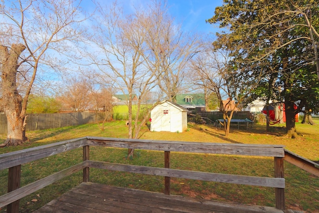 deck featuring an outbuilding, a storage unit, a yard, and a fenced backyard