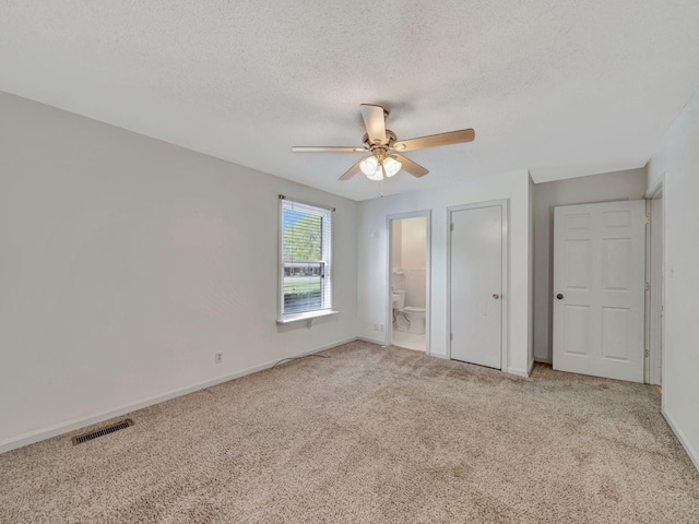 unfurnished bedroom with baseboards, visible vents, light carpet, and a textured ceiling