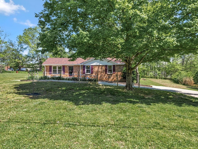 ranch-style home featuring brick siding, a porch, and a front yard