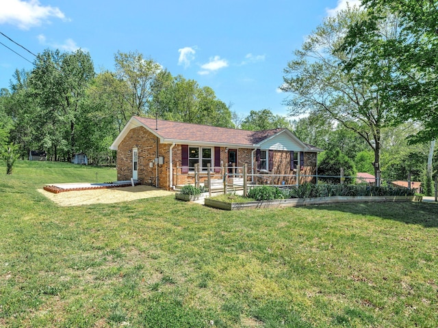 view of front of house featuring a front lawn, a patio area, and brick siding