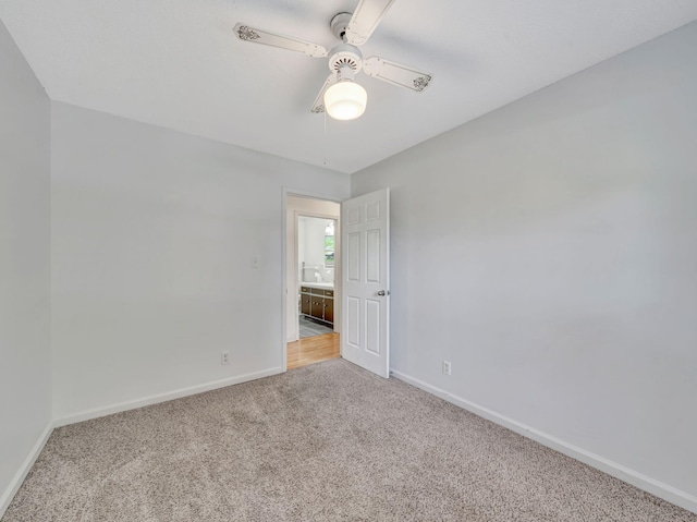 spare room with carpet floors, ceiling fan, and baseboards