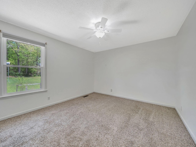 empty room with carpet flooring, ceiling fan, and baseboards
