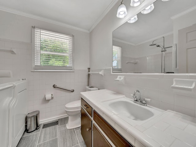 bathroom featuring visible vents, toilet, tile walls, vanity, and tiled shower