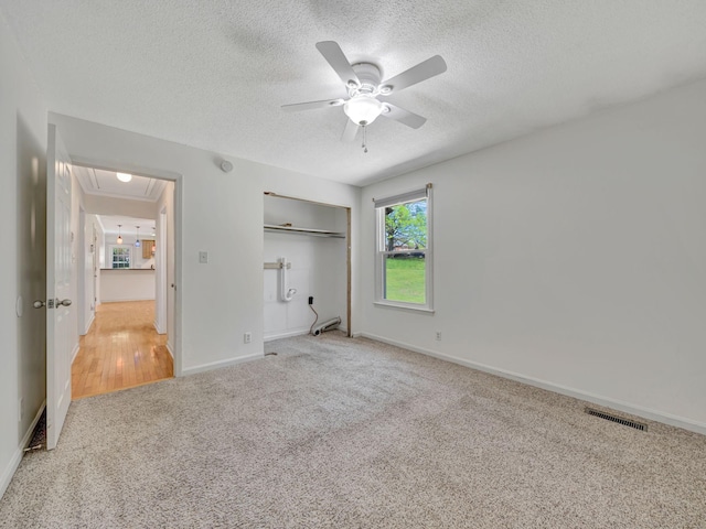 unfurnished bedroom with attic access, visible vents, baseboards, and carpet floors