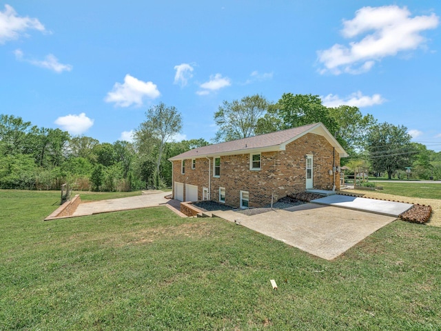 back of house with a garage, brick siding, concrete driveway, and a lawn