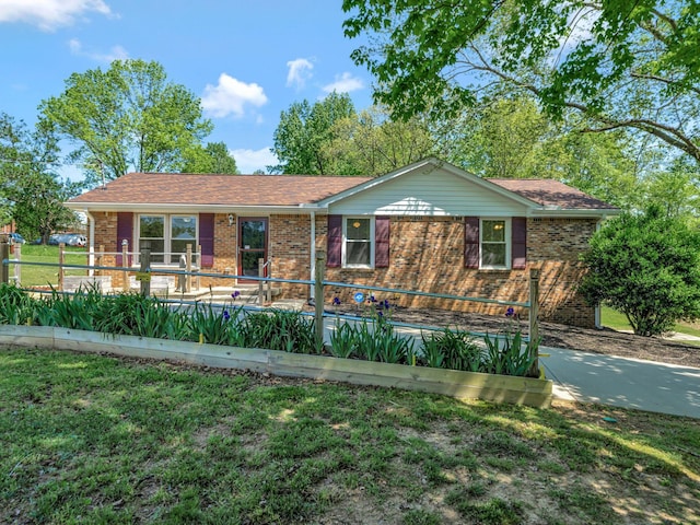 single story home with a front lawn, fence, and brick siding