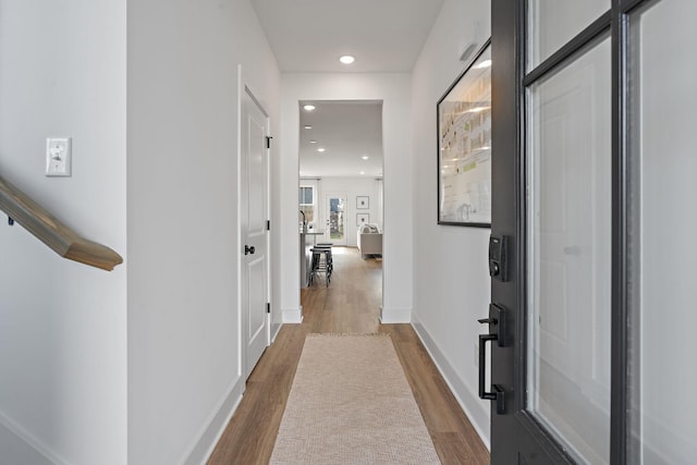 hall with dark wood-style floors, recessed lighting, and baseboards