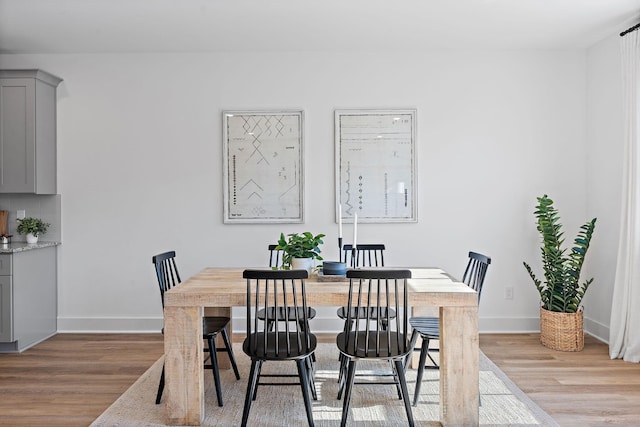 dining area featuring baseboards and light wood-type flooring