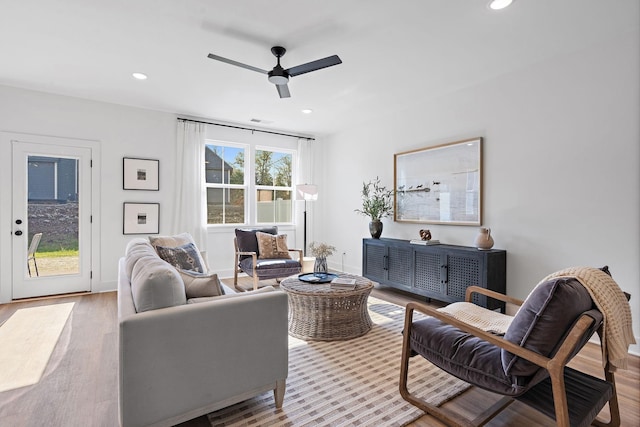 living room with wood finished floors, a ceiling fan, visible vents, and recessed lighting