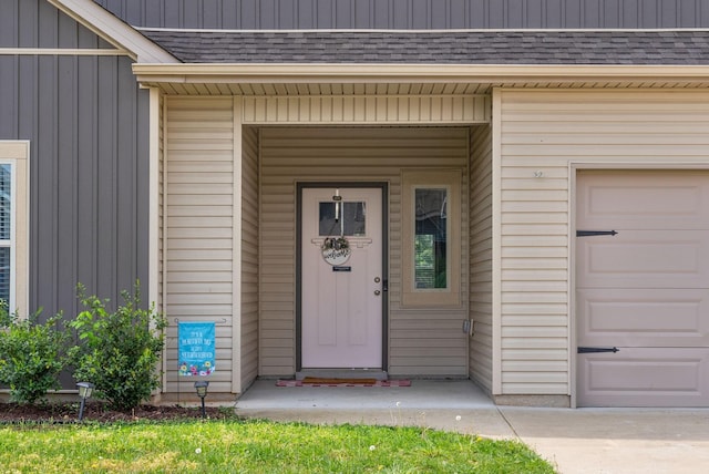 doorway to property with roof with shingles and board and batten siding