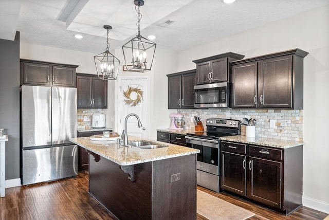 kitchen featuring light stone countertops, a sink, stainless steel appliances, recessed lighting, and dark wood-style floors