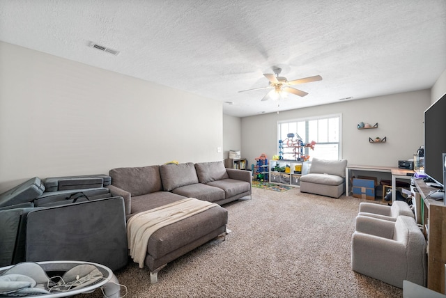 living area with carpet flooring, a textured ceiling, ceiling fan, and visible vents