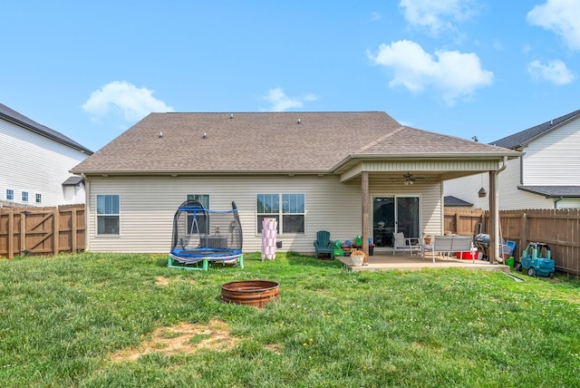rear view of house featuring a fenced backyard, a trampoline, ceiling fan, and a patio area