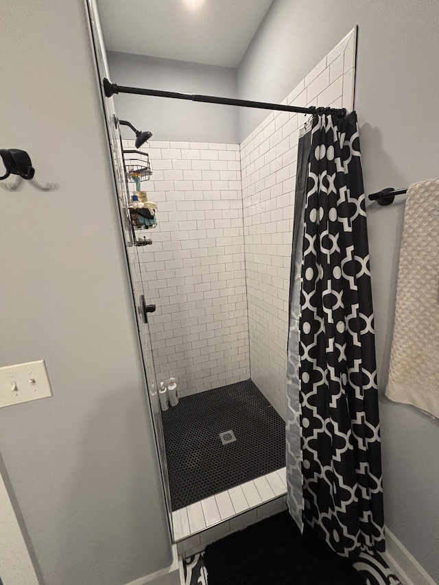 full bathroom featuring a stall shower and baseboards