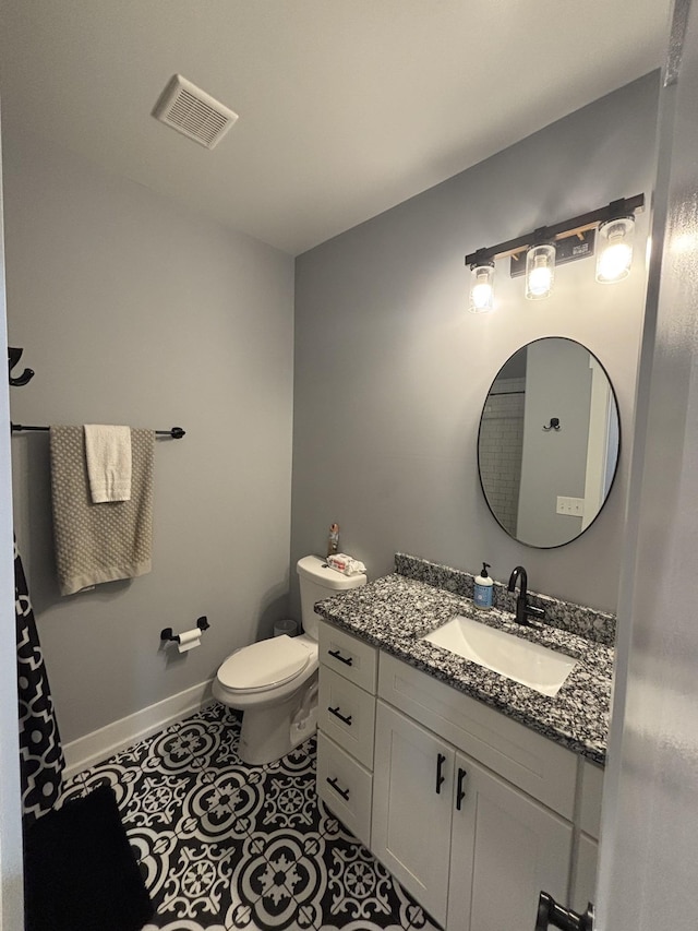 bathroom featuring toilet, vanity, baseboards, and tile patterned flooring